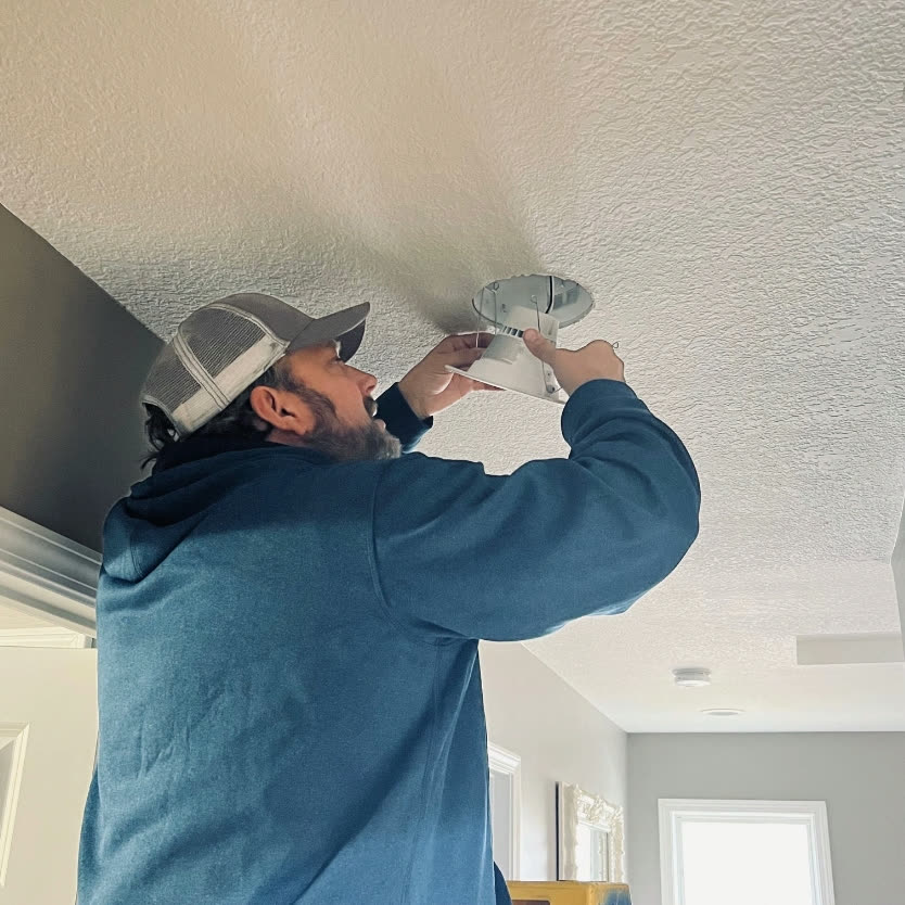 Matthew installing a recessed ceiling light